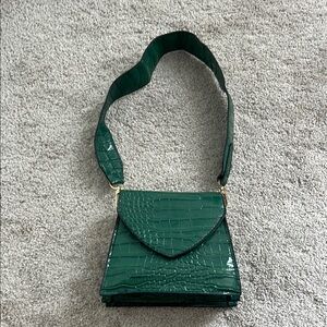 Small green purse w/ gold chain attachment.